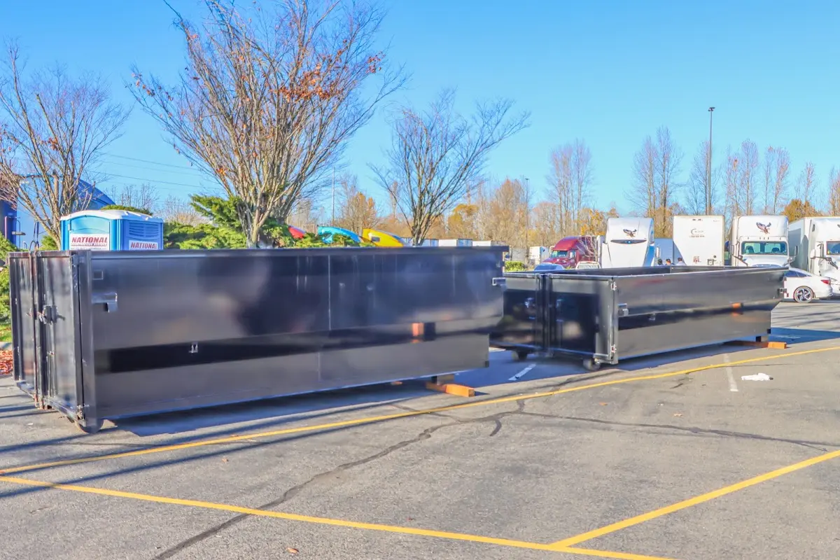 Professional dumpster rental service with roll-off container on residential driveway in Alfred